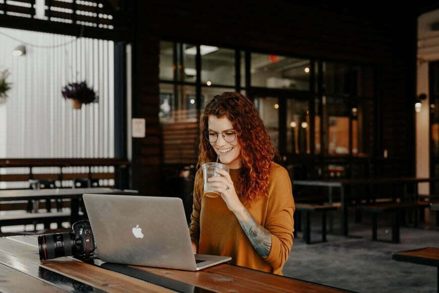 Women drinking coffee while looking at her laptop